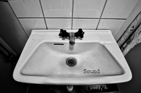 Closeup of a grungy sink in black and white with the word sound.の写真素材