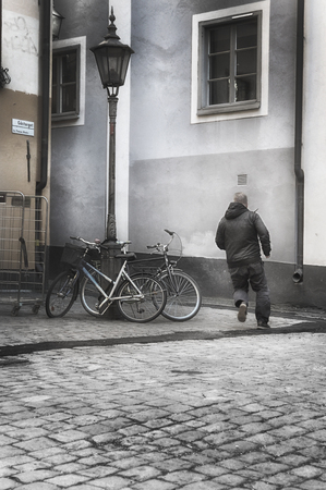 Unrecognizeble man running in old town.の写真素材