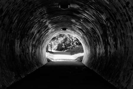 Dark dirty tunnel with park at the endの写真素材
