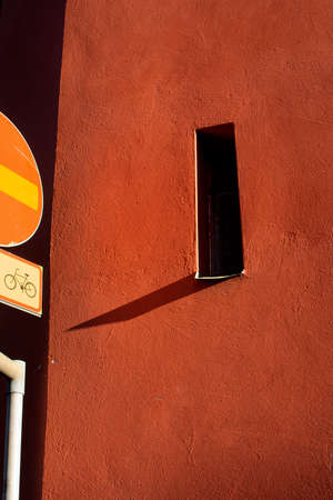 Old orange wall and part of traffic sign no bicycle