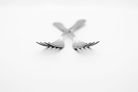 Two isolated crossing forks on white background with depth of field