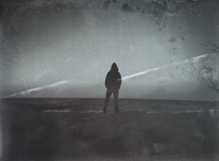 Heavy textured image of person in silhouette looking out over the seaの写真素材
