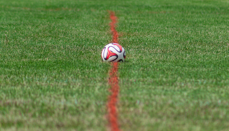 Red and White Soccer Ball at Midfieldの写真素材
