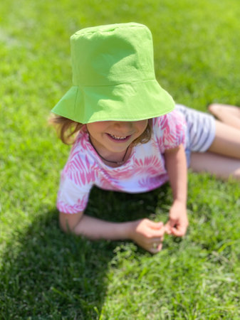 Close-up of a summer portrait of a girl in a green hatの写真素材