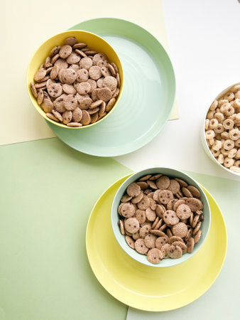Three colorful bowls with breakfast cereals on a colored background.の写真素材
