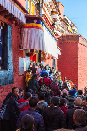 Shigatse, Tibet, China - November 16, 2019:  Tibetan people queuing on a shrine inside the Baiju...
