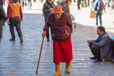 Lhasa, Tibet, China - November 15, 2020: Old Tibetan men in traditional Tibetan clothes and walking stick. For prayer purpose people walking on the bakuo road around the Jokhang Temple.のeditorial素材