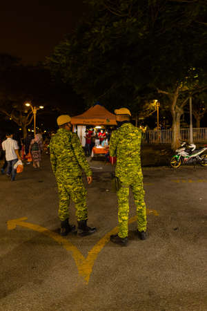 Street food night market at Putrajaya, near Kuala Lumpur. Security officers monitor compliance with...