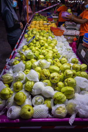 Kuala Lumpur, Malaysia - October 16, 2020: A vegetable stand with Lohan Guava or Jambu Batu fruits on the counter, in the street market. Luo Han Guave, a very special Malaysian fruitのeditorial素材