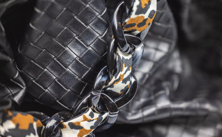 Close up of the chain of a ladies handbag. Leather bag with black textured string. Fashion concept...