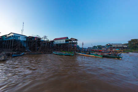 Kampong Phluk Floating Village on Tonle Sap lake near Siem Reap, Cambodia during sunset. The Stilt houses of the floating town. Exotic places South East Asia. Boats cruising around and selling goodsの写真素材