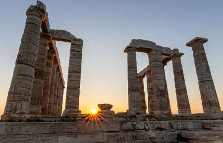 Amazing colorful sunset at the Temple of Poseidon, archaeological site of Sounion, Attica. Cape Sounion, Greece. A sunset behind the citadel on a hill at the shoreline of Mediterranean Sea.のeditorial素材