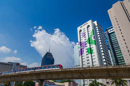 Kuala Lumpur, Malaysia - November 11, 2020: Cityscape with the public transport trail or sky train MRT in the city of Kuala Lumpur. White cumulus clouds on the blue sky on a hot day in Malaysia.のeditorial素材