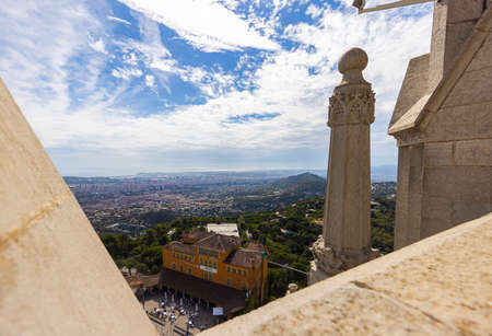 Barcelona, Spain - September 23, 2021: View from the roof of the church of the Sacred Heart of Jesus at the peak of the Parc Tibidabo, over the city. Aerial cityscape. In the foreground the stone statues.のeditorial素材