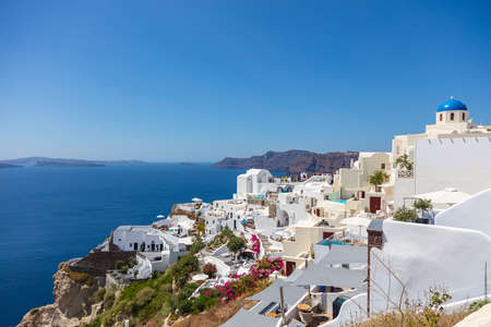 Santorini, Greece - August 7, 2021: View over the roofs of the typical houses of Santorini, island in the cyclades archipelago in the Aegean Sea. White houses under the blue sky. Village high on the cliffのeditorial素材