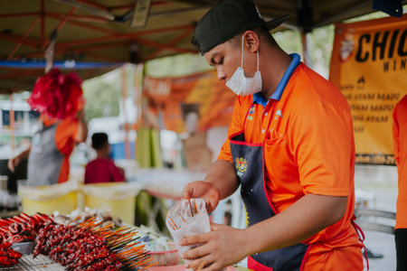 Kuala Lumpur, Malaysia - June 21, 2022: Young man preparing traditional Kundasang Honey chicken...