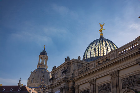 Dresden, Germany - June 28, 2022: At the Academy of Arts on the River Elbe Terraces. Golden statue on the glass dome of the historical building. Landmark and eye catcher of the city skyline. cityscapeのeditorial素材