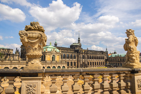 Dresden, Germany - June 28, 2022: Sandstone statue in the Dresdener Zwinger. The 300 year old figures have been extensively restored. View across the Zwinger to the clock tower of the Hofkircheのeditorial素材