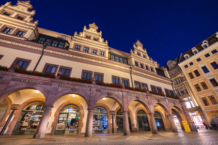 Leipzig, Germany - July 02, 2022: The city center of the saxony metropolis at night. The old town hall or city hall illuminated in summer time. People walking on the street and enjoying the eveningのeditorial素材
