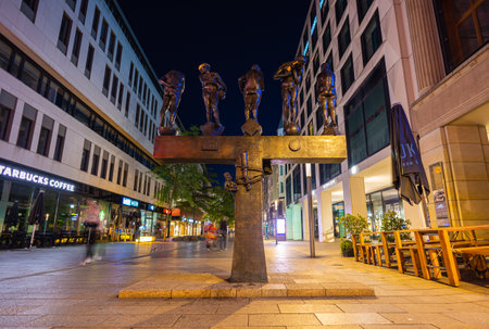 Leipzig, Germany - July 02, 2022: The city center of the saxony metropolis at night. The Grimmaische Strasse with the untimely contemporaries, a sculpture on the walkwayのeditorial素材