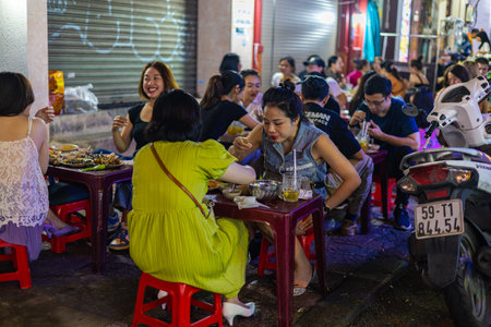 Ho Chi Minh City, Vietnam- November 9, 2022: Street food store in the streets of Saigon. Customers...
