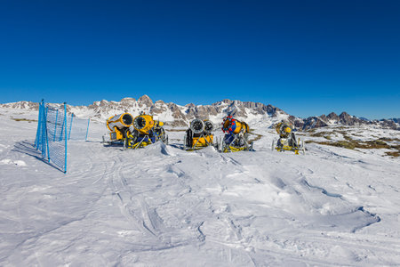 Falcade, Italy - February 15, 2023: The future of winter sports, snow cannon or snow gun in the Dolomites mountains. Climate change is reducing the amount of snow even on the mountain peak.のeditorial素材