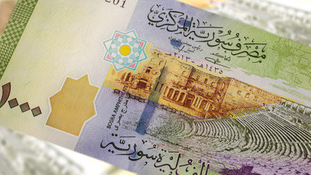 A close-up of a Syrian 1000 Pound banknote reveals intricate art and design. Amidst the country's...