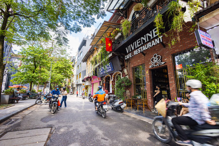 Hanoi, Vietnam - May 28, 2023: Enchanting Old town streets reveal a vibrant tableau: motorcycles and bicycles whizzing by, creating a melodic cacophony. This energetic scene showcases Vietnam cultureのeditorial素材