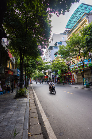 Hanoi, Vietnam - May 28, 2023: Enchanting Old town streets reveal a vibrant tableau: motorcycles and...