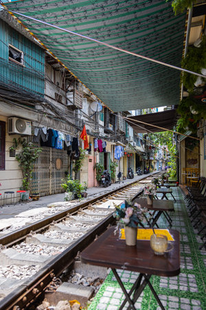 Hanoi, Vietnam - May 28, 2023: Train Street in Hanoi is a narrow, bustling lane with tracks. Close knit houses, adorned with plants, are inches away from passing trains. bars and cafes line the trackのeditorial素材