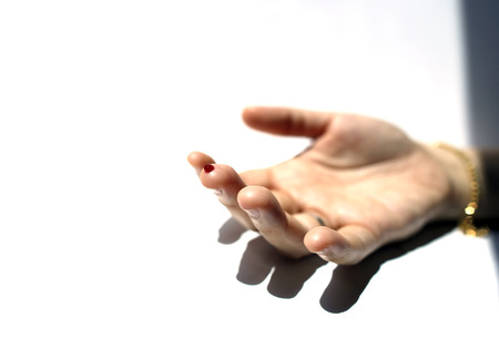A finger with red blood dropの写真素材