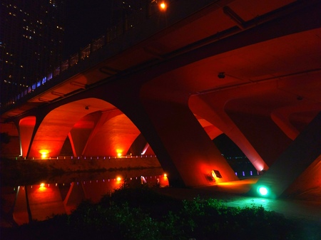 Lights and structure under a bridge in a cityの写真素材