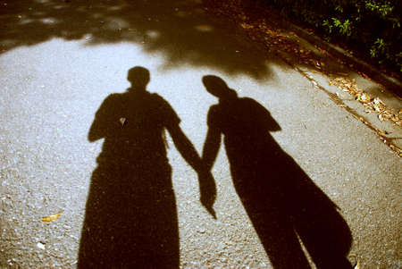 shadow of couple walking holding each others handの写真素材