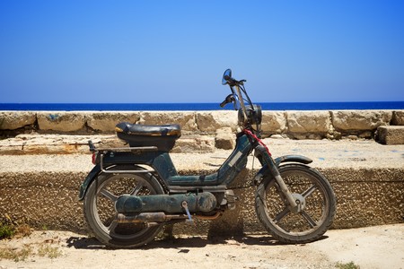 Motor scooter leaning against a wallの写真素材