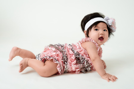 baby girl with cute floral dress and white backgroundの写真素材