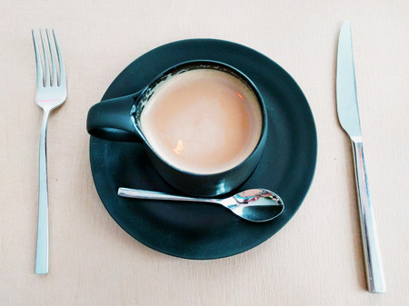 Afternoon coffee Latte in restaurant with knife and forkの写真素材