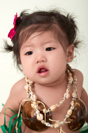 Cute Asian Chinese baby girl dressed in Hawaiian outfit.の写真素材