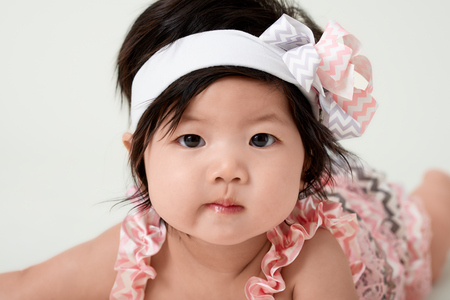 baby girl with cute floral dress and white backgroundの写真素材