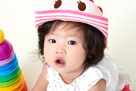 Asian baby girl wearing colorful cute hatの写真素材