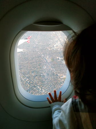 Curious baby on the plane looking out the window for the first timeの写真素材