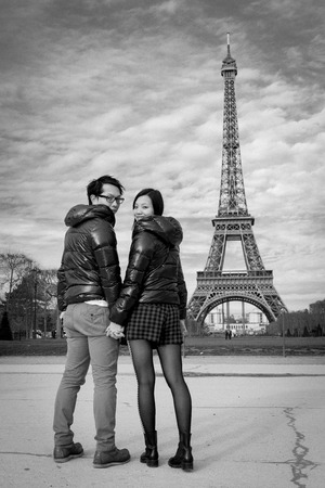Couple in Paris by Eiffel Tower in black and white looking backの写真素材