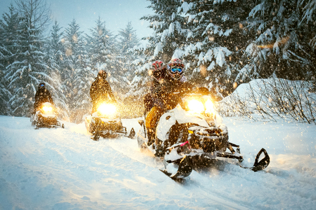 Snow mobile in blizzard through the woods and forestの写真素材