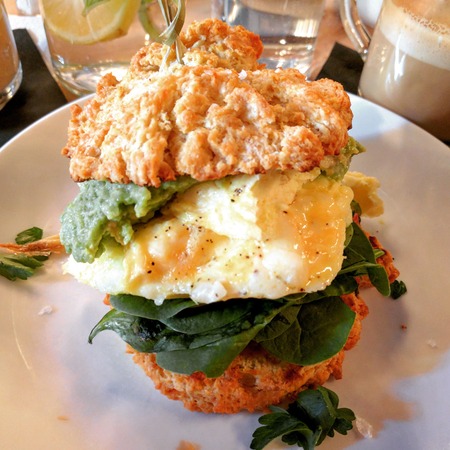 Scrambed eggs, avocado, baby spinach and tomato jam on buttermilk biscuitsの写真素材