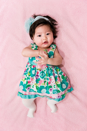 baby girl with cute floral dress and pink backgroundの写真素材
