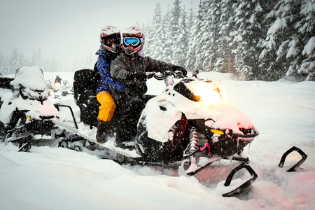 Snow mobile in blizzard through the woods and forestの写真素材