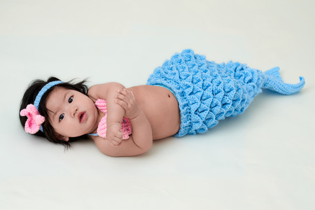 baby girl with cute mermaid outfit and white backgroundの写真素材