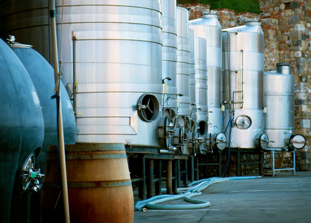 Eight stainless steel made wine brewing tank and a wood barrelの写真素材