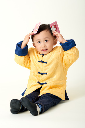 Chinese baby boy in traditional Chinese New Year outfit celebrating Lunar New Yearの写真素材