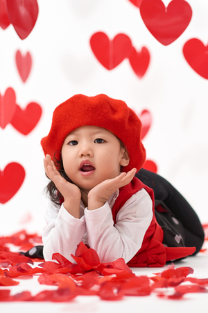 Cute Asian baby girl with hearts and rose pedals on Valentine's Dayの写真素材