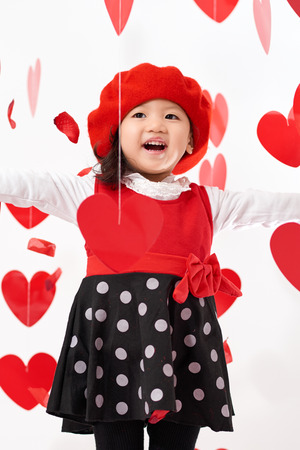 Cute Asian baby girl with hearts and rose pedals on Valentine's Dayの写真素材
